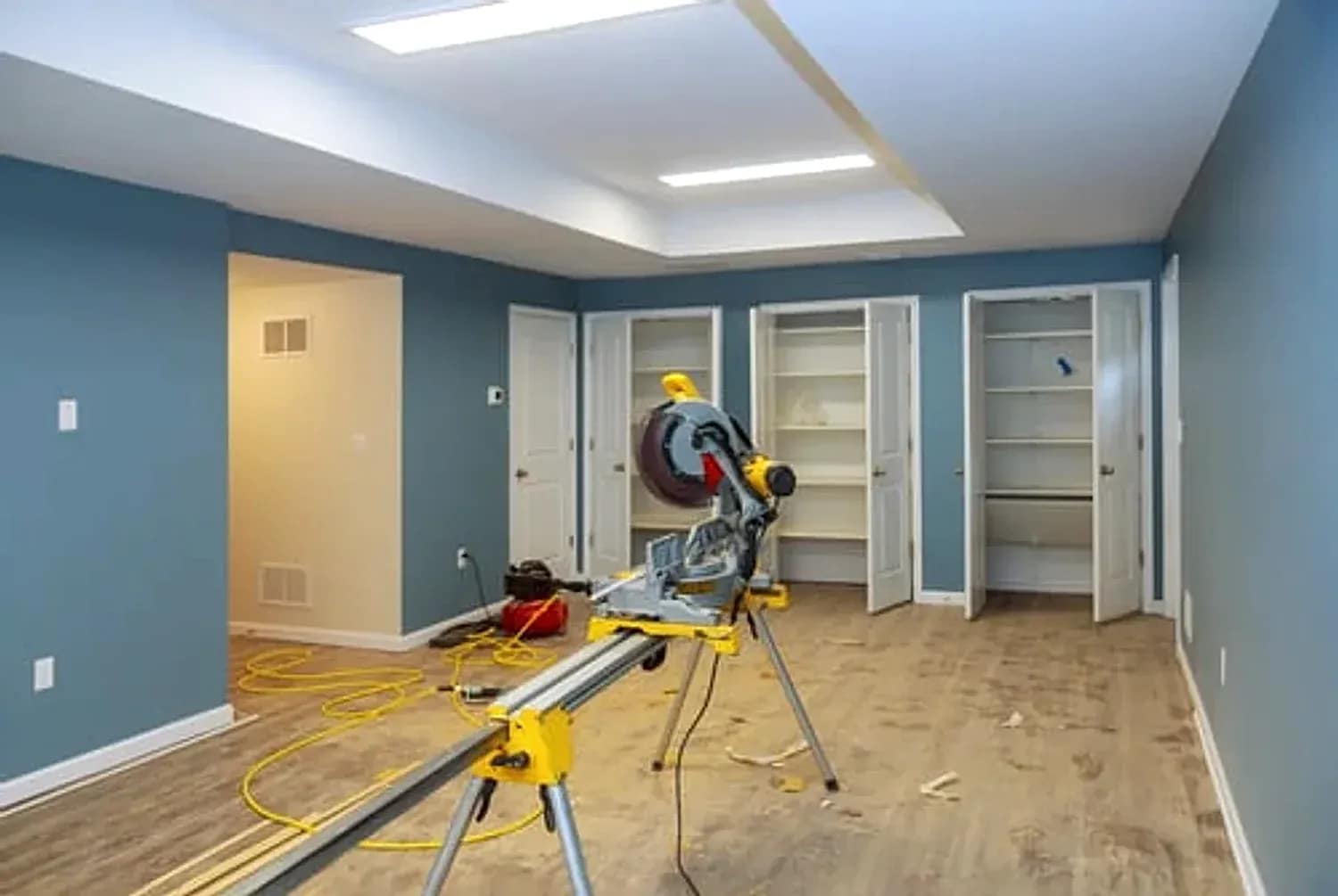 Basement remodeling project in Maryland with newly painted blue walls, recessed lighting and new flooring