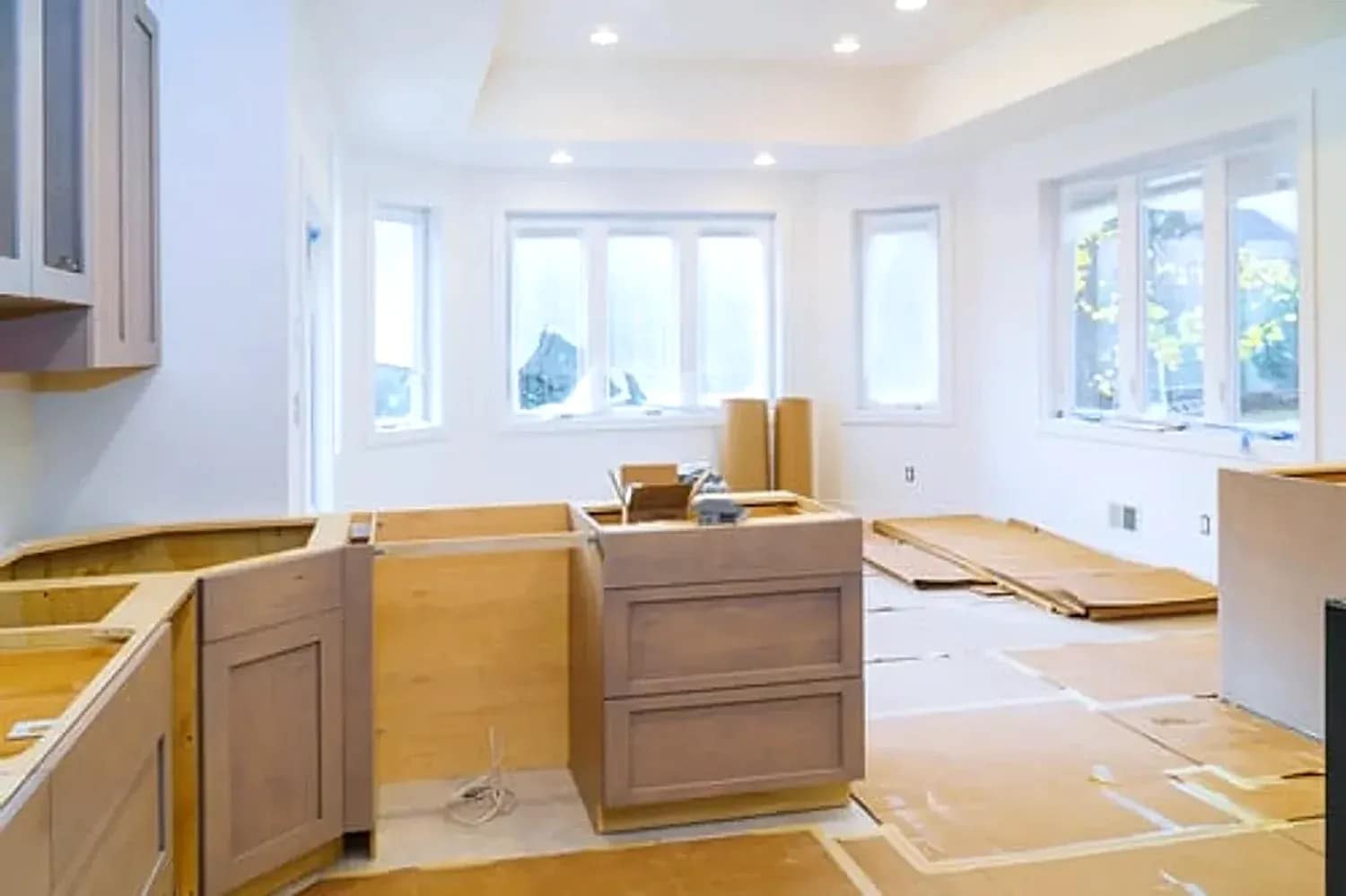 Whole-home renovation in progress with new cabinetry being installed in a bright open-plan room