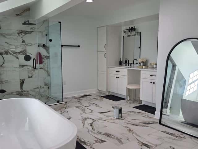 Primary bathroom remodel with a soaking tub, glass shower, double vanity and marble-look tile