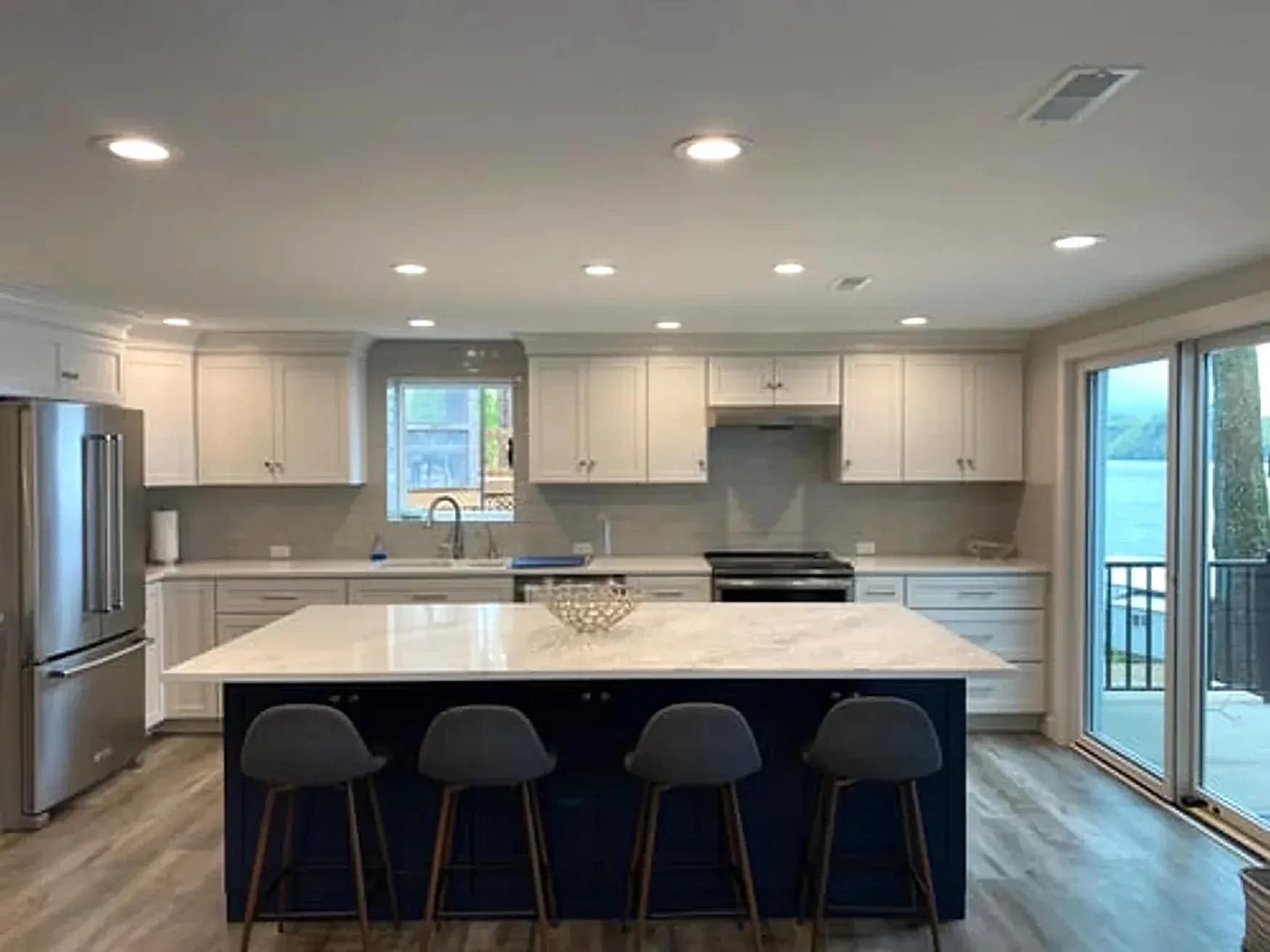 Renovated kitchen in Washington DC with white shaker cabinets, a navy island and quartz countertops installed by Falcon DMV Construction
