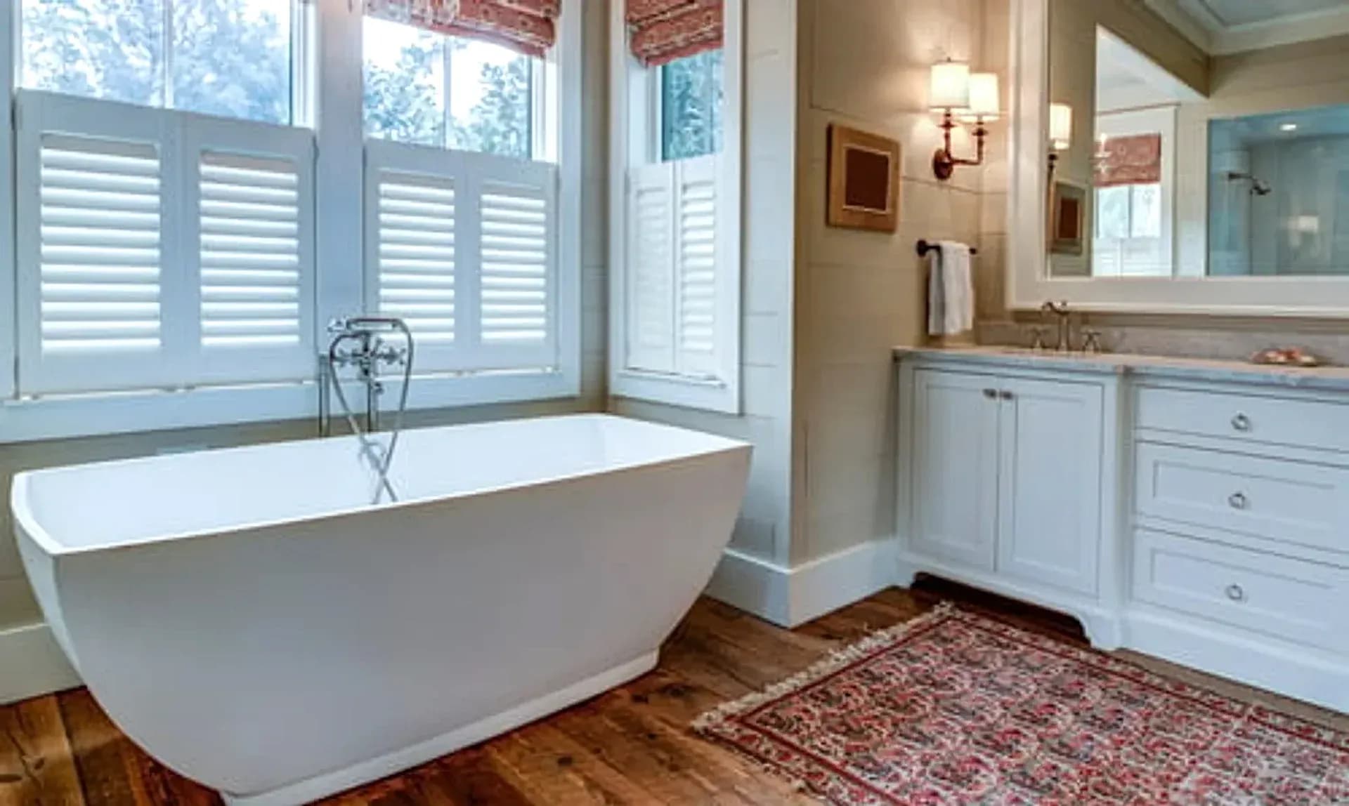Renovated bathroom with a freestanding tub and plantation shutters completed by Falcon DMV Construction